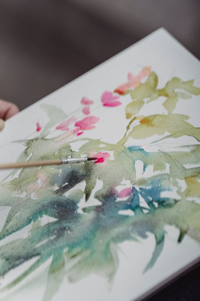 pexels photo 7859199 Vibrant watercolor painting in progress on a sketchbook with brush.